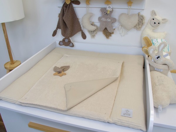 Liebevoll eingerichteter Wickelplatz mit Wickelauflage in Light Sand aus Waffelpique und Frottee – harmonisch abgestimmt mit Dekoration in Naturtönen.